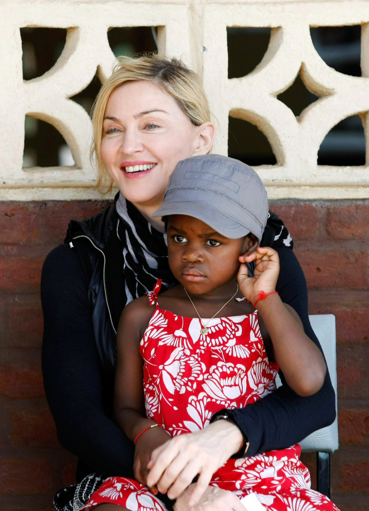 Image: U.S. pop star Madonna holds her adopted Malawian child Mercy James during a visit to Gumulira village